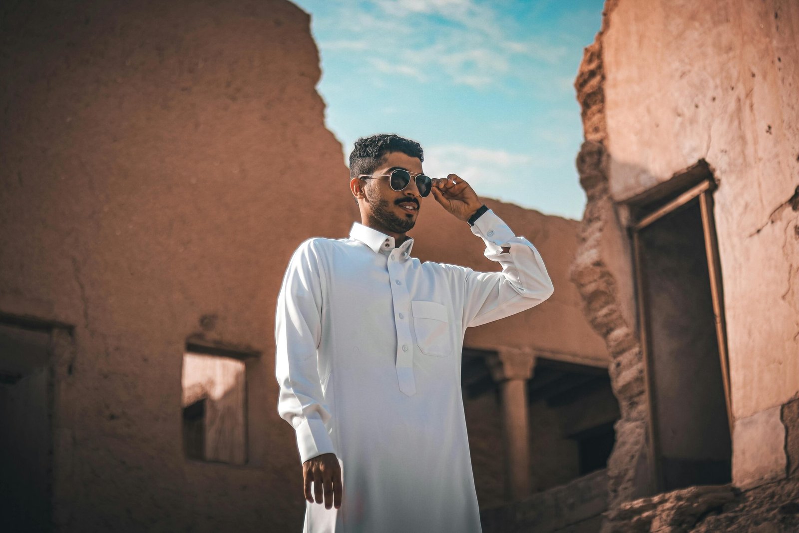 Man in sunglasses explores ancient ruins in Riyadh. Cultural and urban exploration captured.